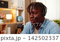 African American young man on home table talking with client as call center operator wearing headset 142502337