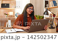 Indian woman on home table closes support request after solving problem during laptop support call 142502347