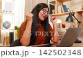 Indian woman on home table smiles after solving customer support problem during online service call 142502348