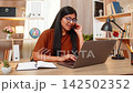 Indian woman on home table greets customer as support operator using headset and laptop for service 142502352