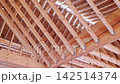 Wooden beams are arranged in roof framing beams structure of building under construction 142514374