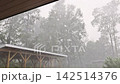 Heavy rain floods ground near shed as during thunder storm, in quiet countryside setting. 142514376