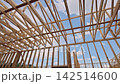 Workers are building new structure with wooden beams frames with residential area. 142514600