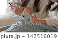 スマートフォンを使う女の子とお母さん 142516019