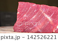 Closeup dolly shot of fresh raw beef steak piece on wooden cutting board, premium red meat culinary cooking ingredient 142526221