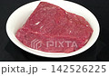 Fresh raw beef steak piece slowly rotating on white round ceramic plate, premium red meat culinary cooking ingredient 142526225