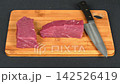 Fresh raw beef steak cuts arranged with chef knife on wooden cutting board, gourmet cooking culinary preparation flat lay 142526419