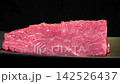 Eye level shot of fresh raw beef tenderloin steak rotating on black plate, premium red meat culinary cooking ingredient 142526437