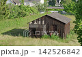 An old wooden barn and wind turbines in city 142526842