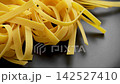 Organic Fettuccine pasta nests on black kitchen plate. Rotation 142527410