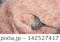 Unique textures and pink color of organic Himalayan salt in metallic spoon close up. Healthy nutritious seasoning 142527417