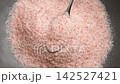 Crushed Himalayan pink mineral salt in a metal spoon. Fresh raw exotic culinary ingredient. Top view. Rotation 142527421