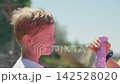 A boy is having water sprayed in his face outdoors profile close-up 8 year old slow motion 142528020