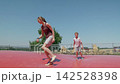 A brother and sister are running on a trampoline outdoors slow motion 142528398