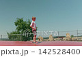 A boy is jumping on a trampoline outdoors slow motion 142528400