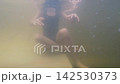 Slow motion view of young girl swimming in murky thermal water moving her fingers 142530373