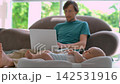 Father working on laptop while baby moves in cocoon. Slow motion. 142531916