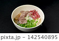 Pouring hot steaming broth into traditional Vietnamese beef pho noodle bowl, authentic culinary street food soup preparation 142540895