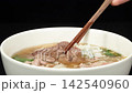 Rotating shot of Vietnamese beef pho noodle soup set on a wooden tray. 142540960