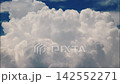 White puffy clouds drifting across a bright blue sky during a sunny afternoon capturing nature in motion 142552271