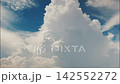 White puffy clouds drifting across a bright blue sky during a sunny afternoon capturing nature in motion 142552272