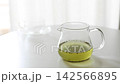 緑茶が入った透明なガラス急須に茶こし一体型の蓋を閉める手元・注ぐ準備（動画素材） 142566895