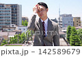 A businessman walking with the cityscape as a backdrop. 142589679