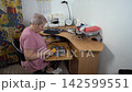 Hobby sewing corner. A woman is engaged in needlework. She sews from scraps of fabric. 142599551