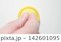 MACRO: Male fingers takes a yellow condom from a white table - Top view 142601095