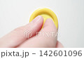MACRO: Male hand puts a yellow condom on a white table - Top view 142601096