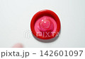 MACRO: Male hand puts a red condom on a white table - Top view 142601097