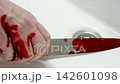 CRIMINAL: Man's bloodied hand puts a knife with traces of blood in the sink 142601098
