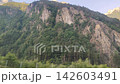 Mountain Peaks and Rocky Slopes Covered with Forest Natural Landscape. Travel view from car window 142603491