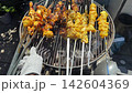 Grilled chicken wings cooking on barbecue grill with golden crispy crust 142604369