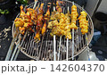 Grilled chicken wings cooking on barbecue grill with golden crispy crust 142604370