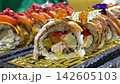 Luxury Sushi Rolls with Salmon Fish Roe and Creamy Fillings Artistically Presented on Ornate Golden Serving Plate in Japanese Restaurant 142605103