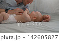 Father kissing baby son's hand as infant holds his finger. Slow motion. 142605827