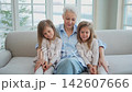 Happy family at home. Two little girls sisters twins grandmother enjoying time together. Good time at home. Grandma granddaughters child kids playing toys hugging together. Family generations 142607666