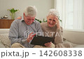 Senior old couple with tablet watching video online. Husband wife spending time together at home. Happy modern mature senior couple using tablet for family entertainment. Old people modern technology 142608338