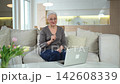 Happy middle aged senior woman siting with laptop talking on video call with friends family. Laughing mature old senior grandmother having fun talking speaking with grown up children online 142608339