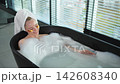 Spa relaxation. Young woman lying in bath with foam bubbles. Girl relaxing in bathroom at home. Pretty female spending morning in bathroom enjoying taking bath. Beauty treatment body skin care concept 142608340