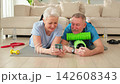 Yoga fitness training online. Senior couple practicing yoga fitness with online lessons on smartphone. Old wife husband watching training on phone before workout. Family doing sports exercise at home 142608343