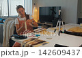 Woman films herself using professional tools to prep hair extensions 142609437