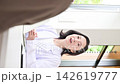 A vertical video showing a clinic image featuring a female doctor smiling and explaining medical counseling, examinations, and health consultations to patients. 142619777