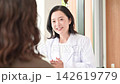 A clinic image video featuring a female doctor smiling and explaining medical counseling, examinations, and health consultations to patients. 142619779