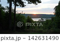 A landscape of the rising sun beyond the lake and trees. 142631490