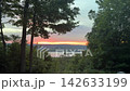 A tranquil dawn scene overlooking the lake and forest before sunrise. A peaceful dawn scene before sunrise, with the lake visible through the trees of the forest. 142633199