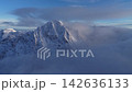 Aerial view of majestic snow covered mountain peaks surrounded by clouds, Norway 142636133