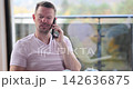 Engaging conversation unfolds on a sunny balcony with city views 142636875