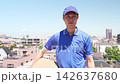 Under the blue sky, the delivery person turns around, showing a serious expression. 142637680